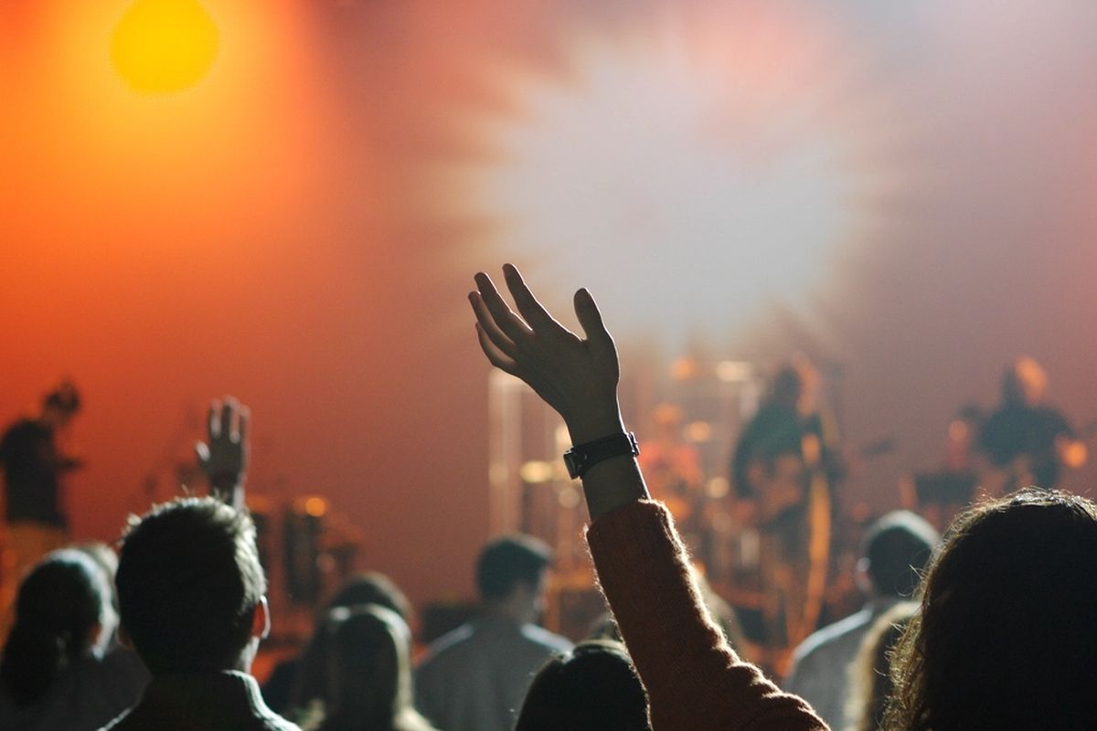 Worshippers with hands lifted in warm golden light